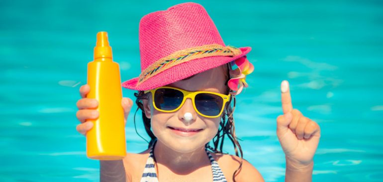 menina na piscina com óculos de sol amarelo